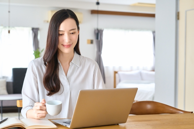 女性_ノートPCとコーヒーカップ_リビング