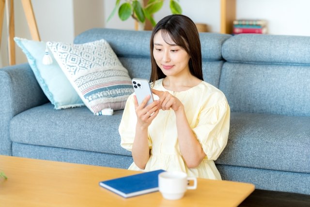 woman-browsing-smartphone-sofa-floor