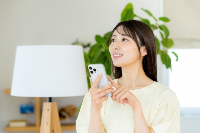 woman-happy-using-smartphone-livingroom