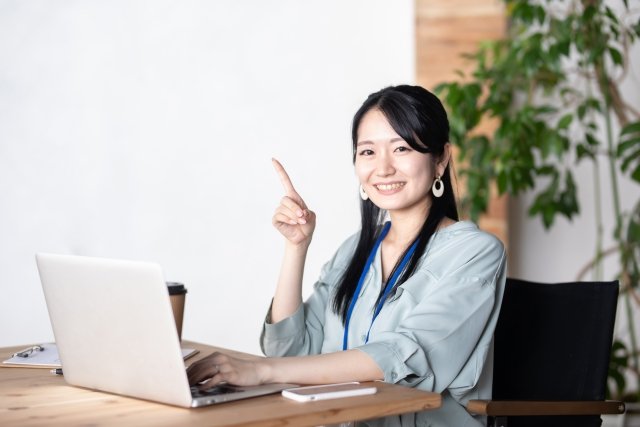 woman-pointing-up-laptop-smiling